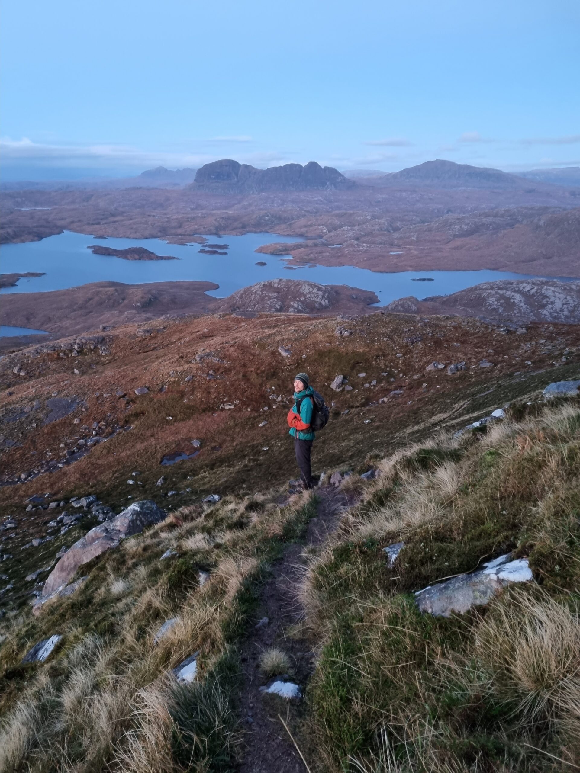 Person on a hiking trail in Assynt, Suilven and Canisp in the distance