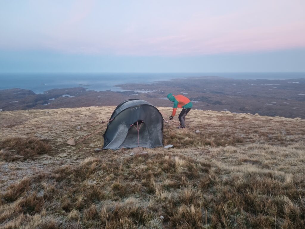 A man and a tent on the summit of Suilven, Scotland
