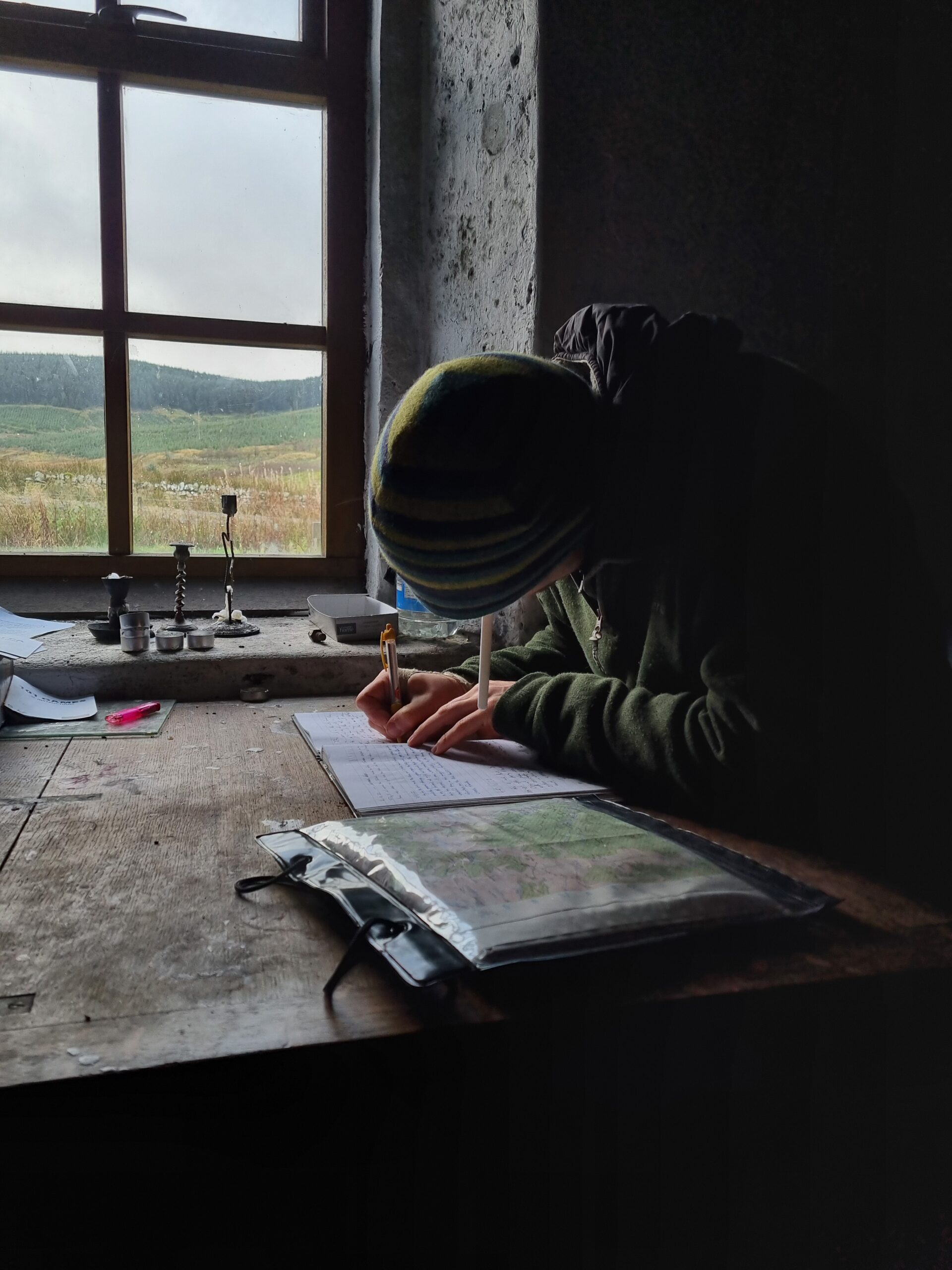 Writing the visitor book in Over Phawhope Bothy, Southern Uplands, Scotland