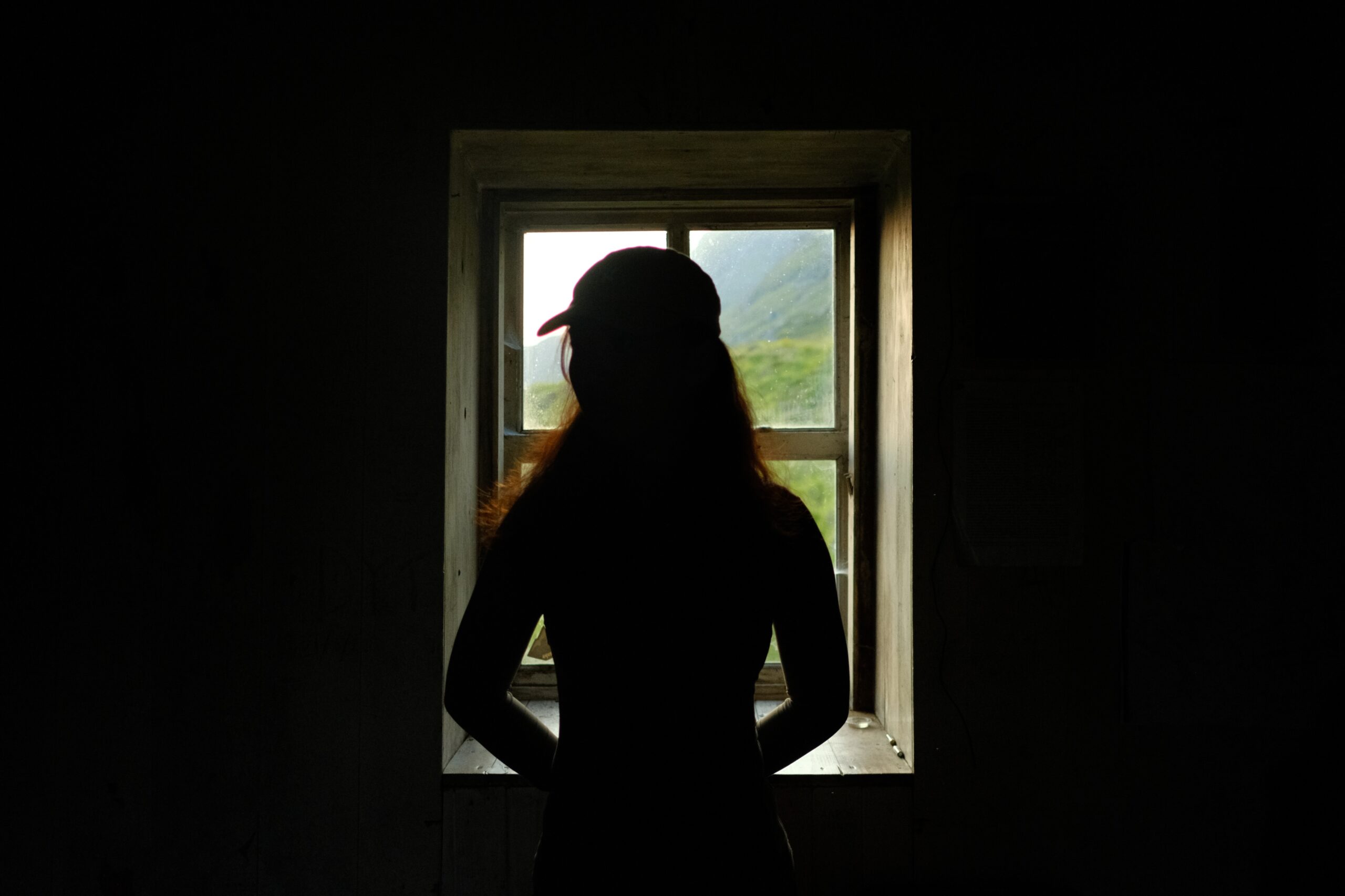 Silhouette of a woman in front of a window, Shenavall Bothy, Scottish Highlands