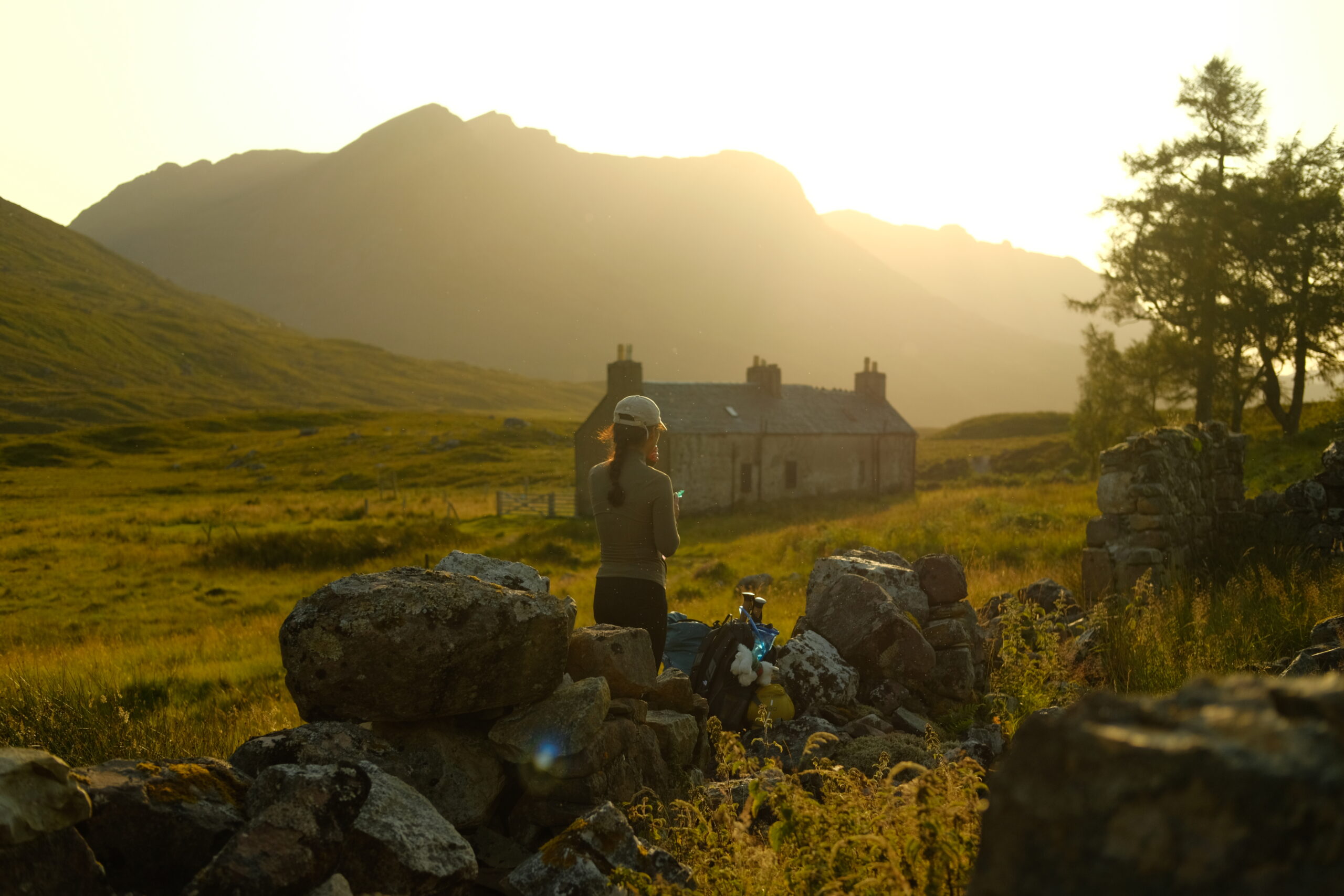 Hiker looking out over Achneigie Bothy in Strath na Sealga, Fisherfield Forest, Scotland