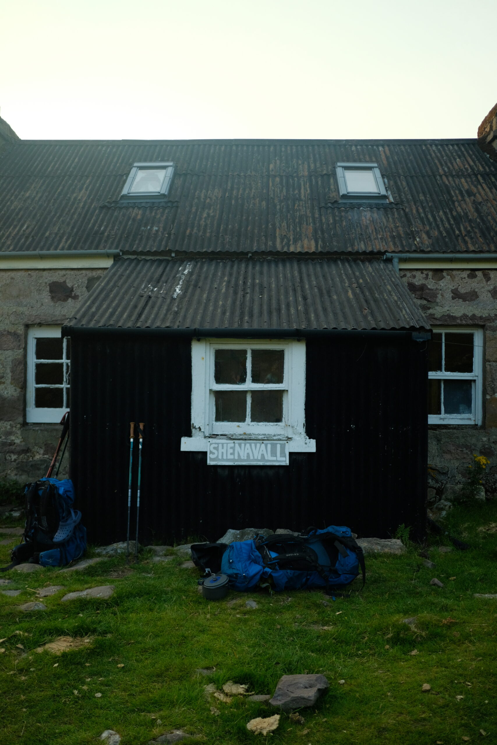 Shenavall Bothy with rugsacks and hiking poles in the Scottish Highlands
